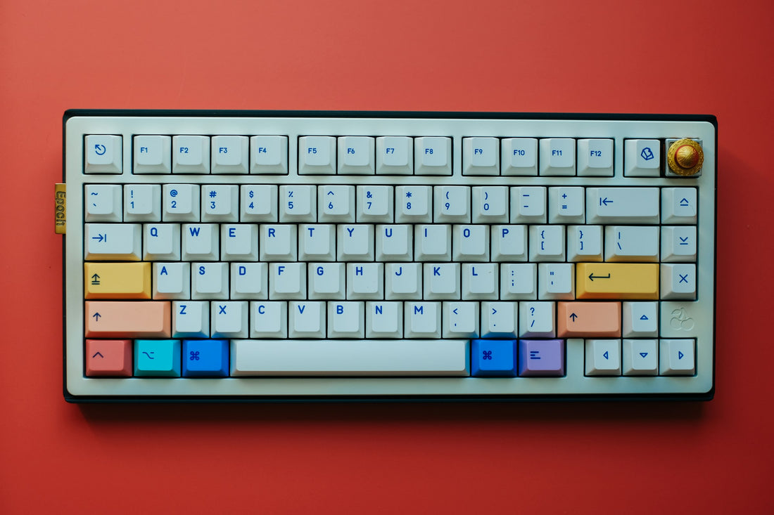Colorful mechanical keyboard with cream, orange, blue and purple keycaps on a red background, showing keycap surface texture